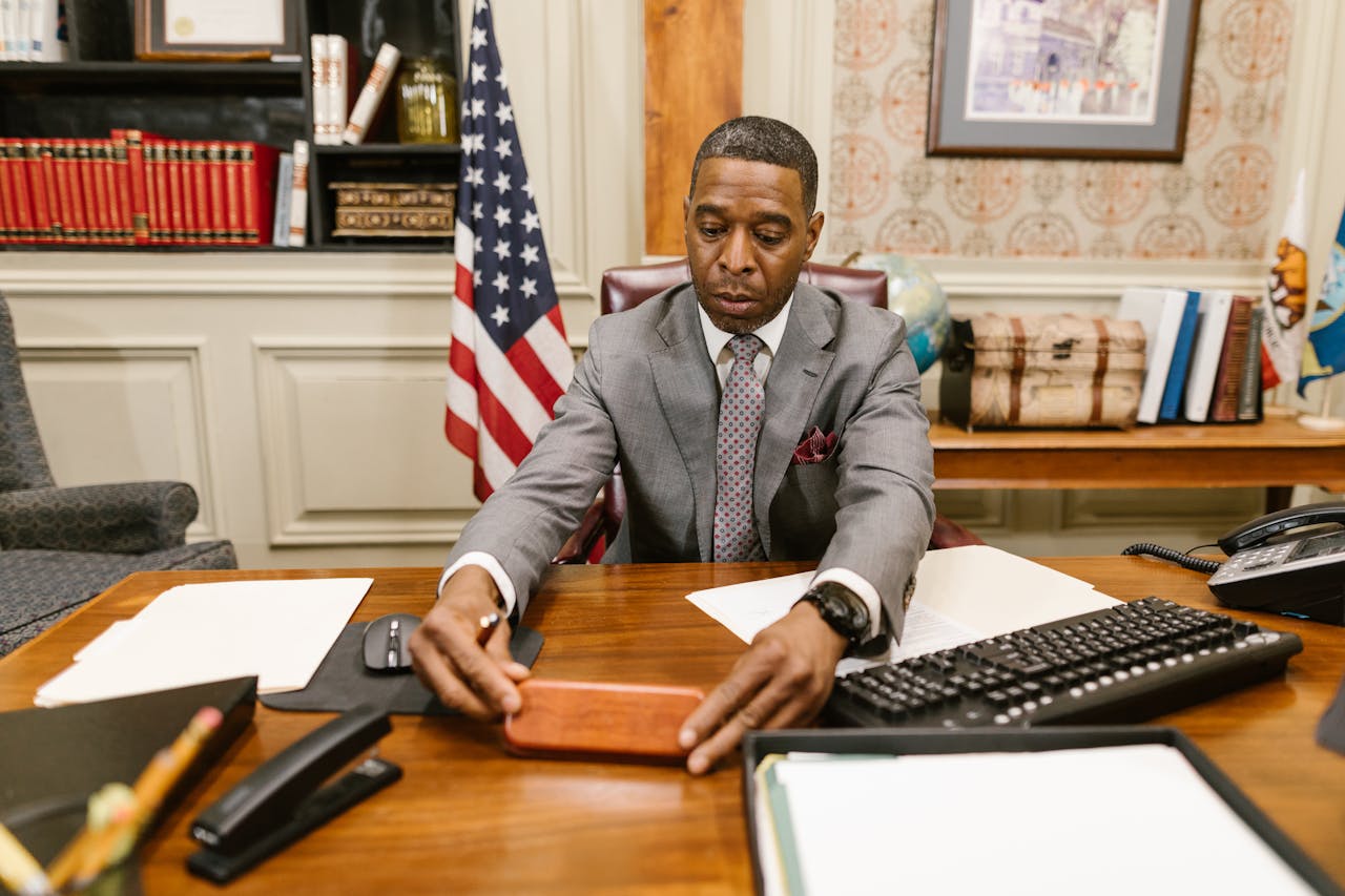 Lawyer seated at desk in office arranging documents with focus and professionalism.